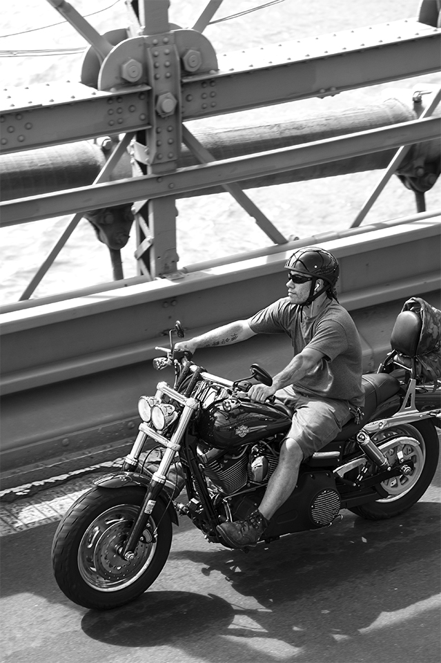 Motorcyclist riding across the lower-level roadway, Brooklyn Bridge